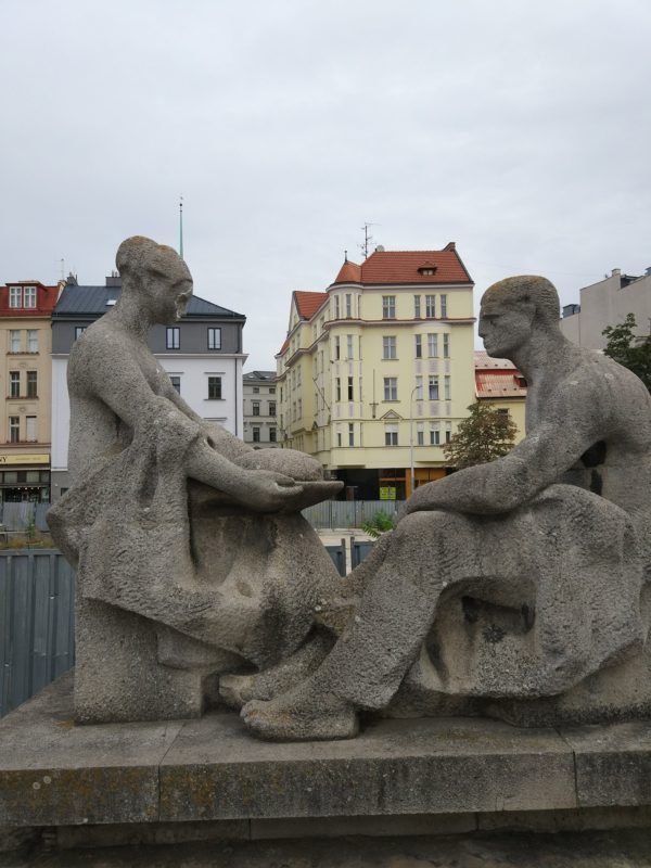 A lady giving a man a piece of bread.