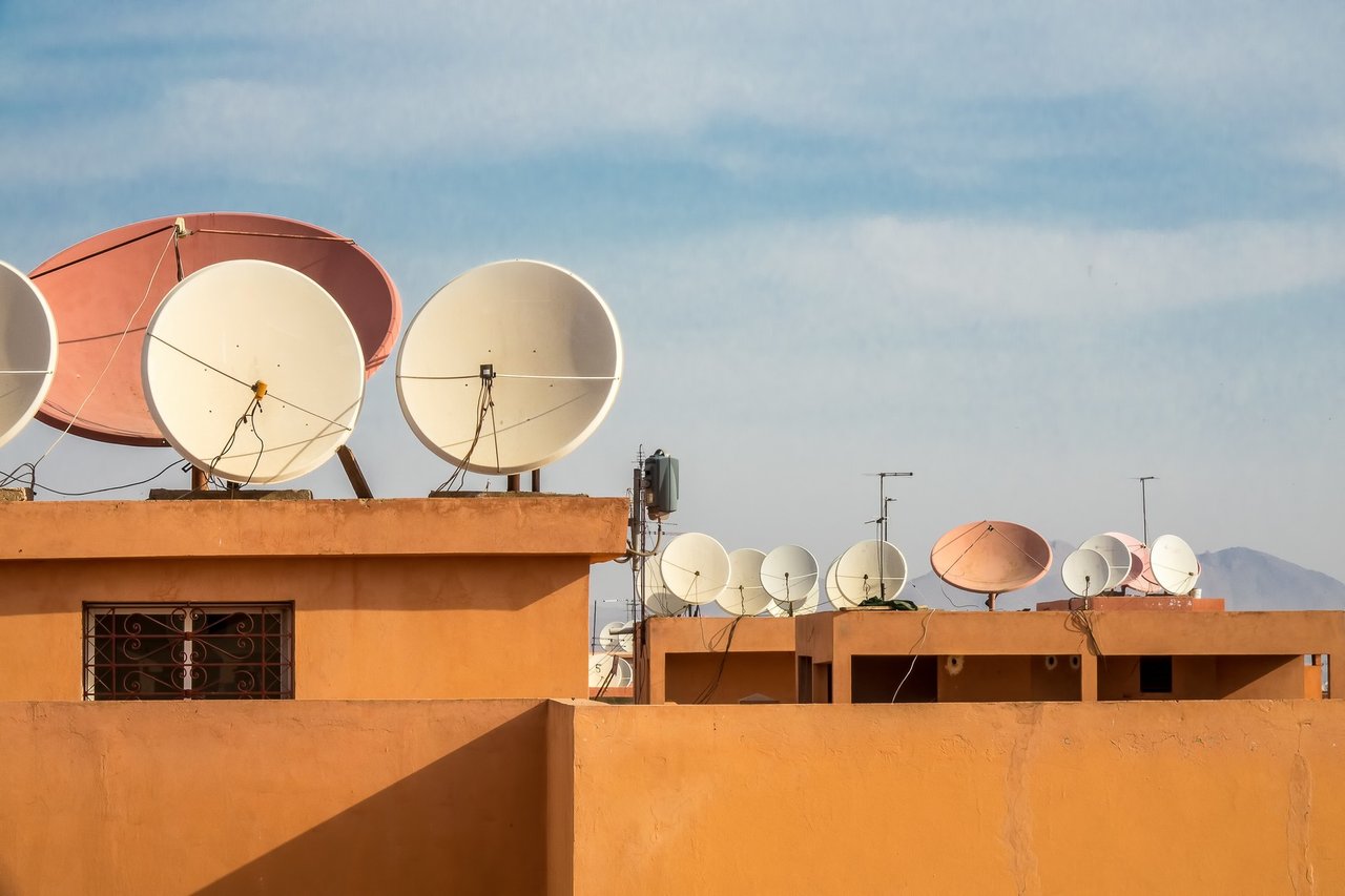 colpo-grandangolare-di-antenne-paraboliche-bianche-sul-tetto-di-un-edificio.jpg