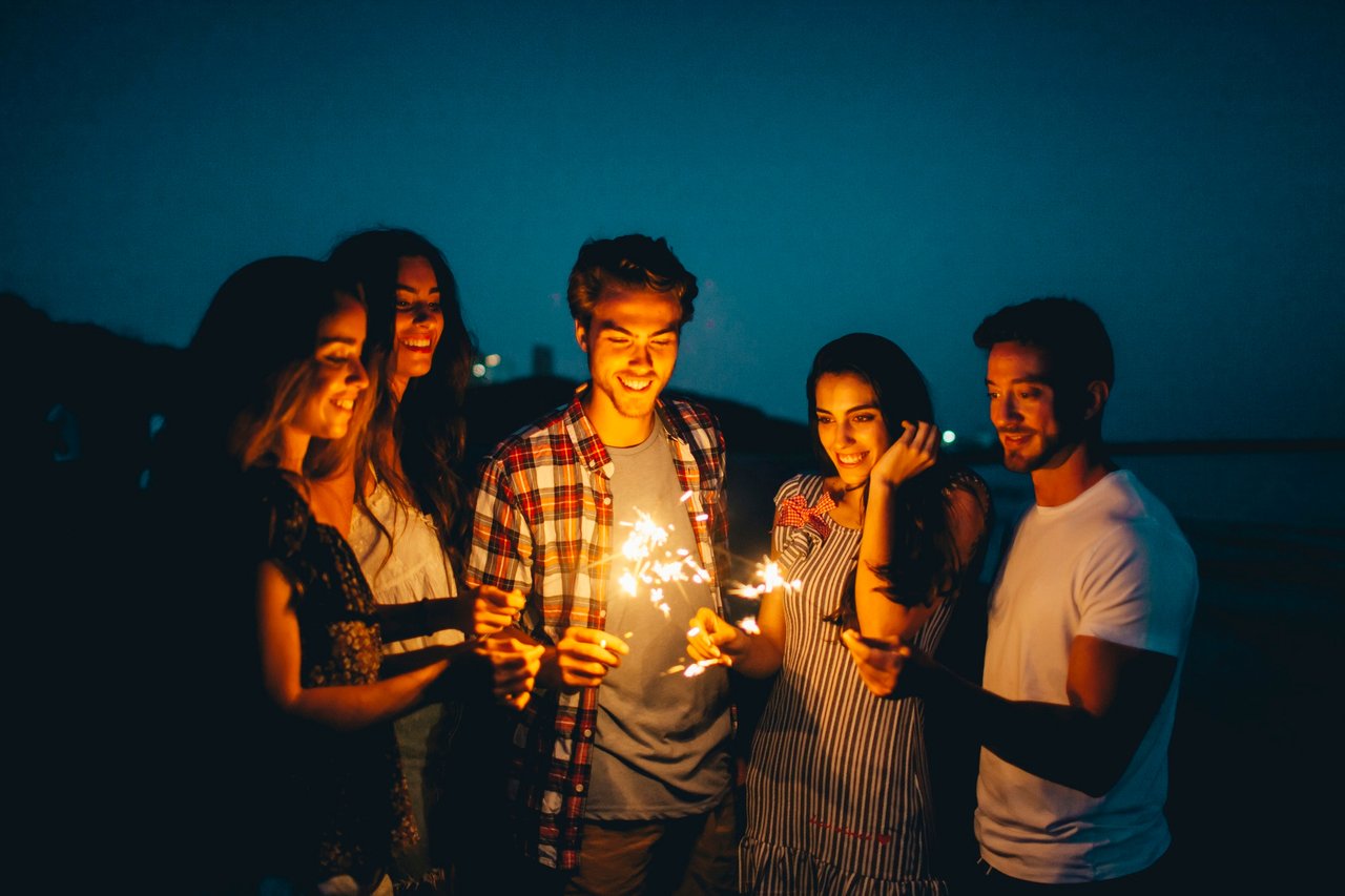 gruppo-di-amici-con-sparkler-in-una-spiaggia-notturna.jpg