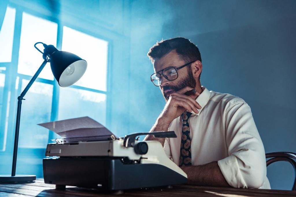 stock-photo-thoughtful-bearded-journalist-sitting-table.jpg