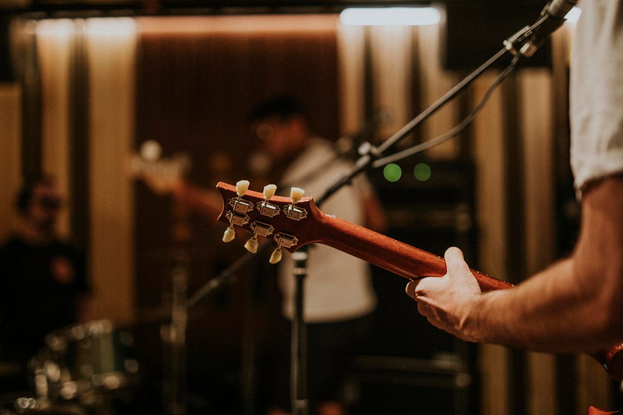 musicista-che-suona-la-chitarra-in-sottofondo-fotografia-estetica.jpg