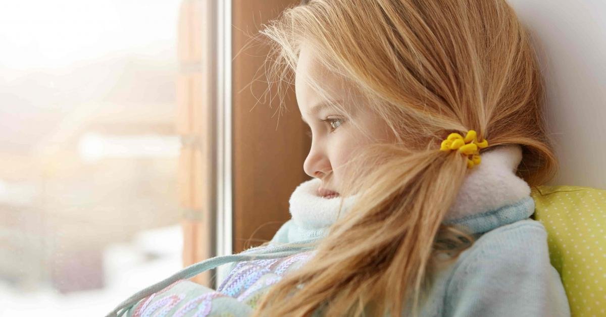 sad-cute-female-child-with-blonde-hair-sitting-on-windowsill-min.jpg