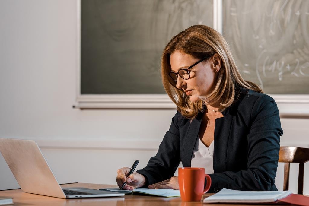 stock-photo-female-teacher-sitting-computer-desk.jpg