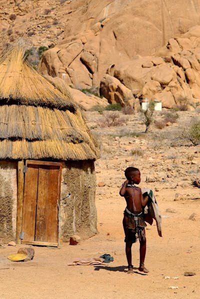 free-photo-of-boy-from-african-tribal-village-in-front-of-hut.jpeg