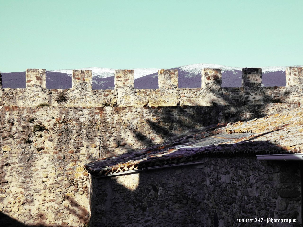 A glimpse of the snow-capped peaks of the Sierra de Guadarrama, seen from the walls of the Arrabal