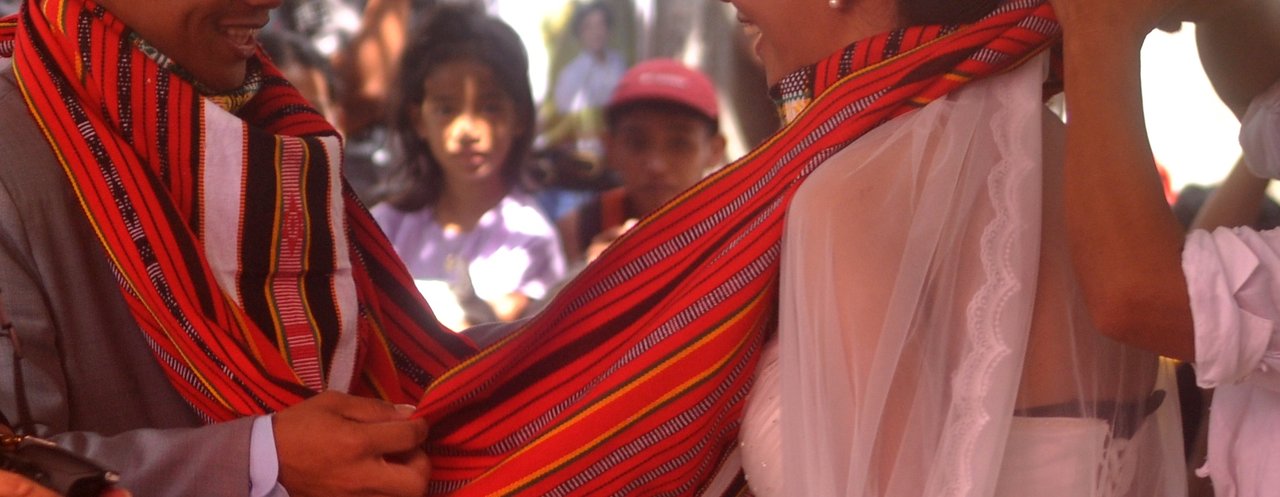 A tapis tied around each neck of the newlyweds