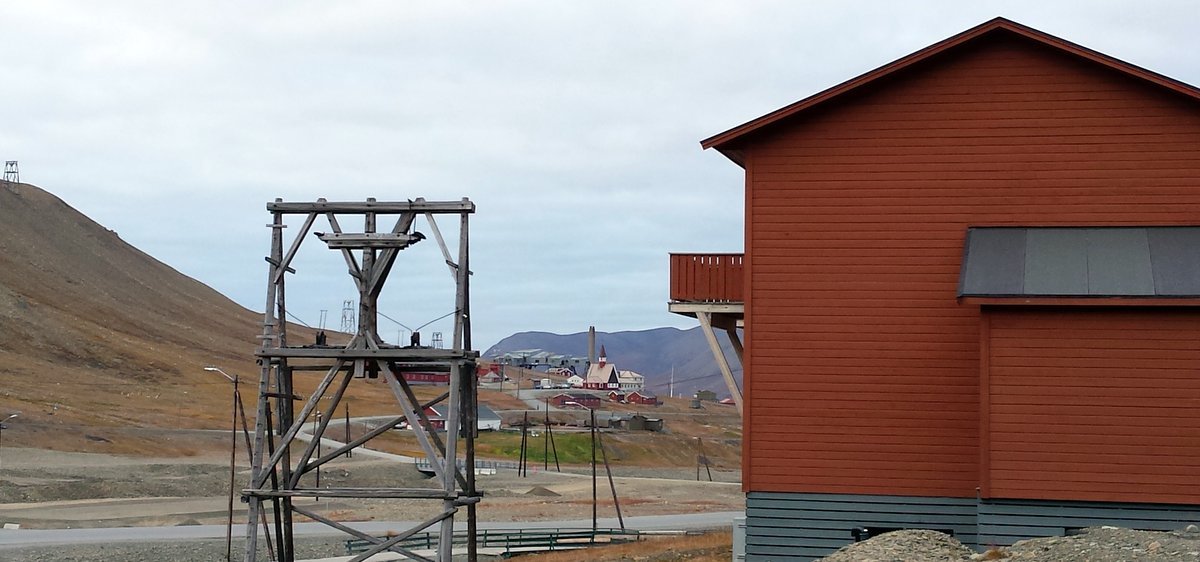 Old frames from the mining cable system near colorful Longyearbyen housing.