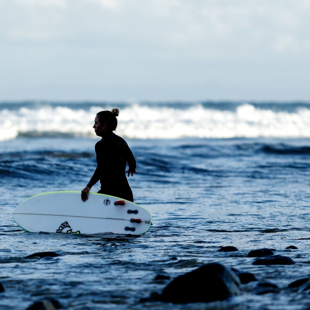 A couple of girls paddle out...