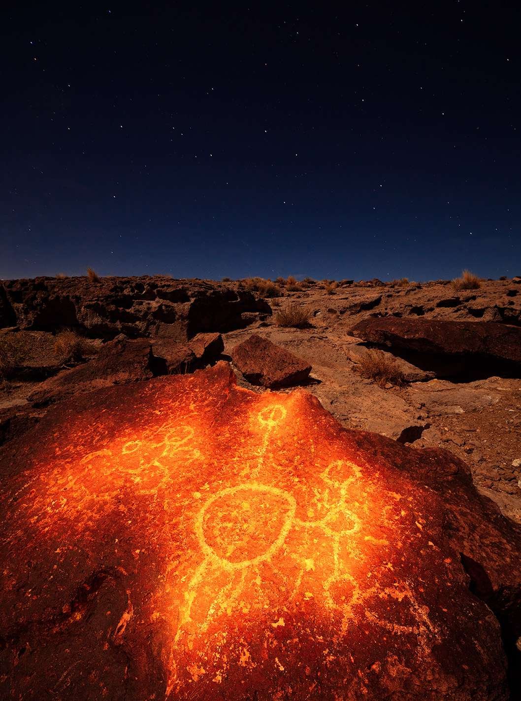 古老美国本地人刻在岩石上的文字在Vulcanic平原的夜空下。