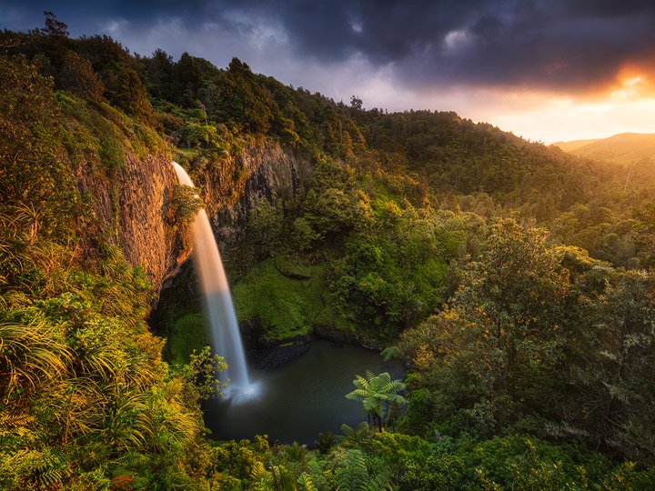The Bridal Veil waterfall glowing in orange light during sunset