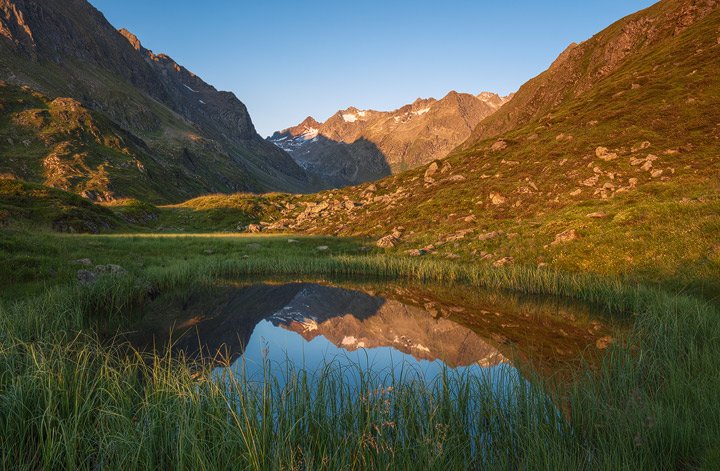 Reflection of the Stubai Mountains in a little lake