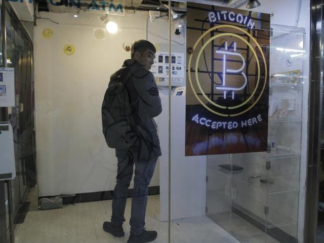 Ein Mann benutzt einen BitCoin-Automaten in HongKong