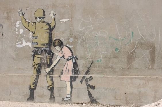 Banksy graffiti of girl patting down soldier