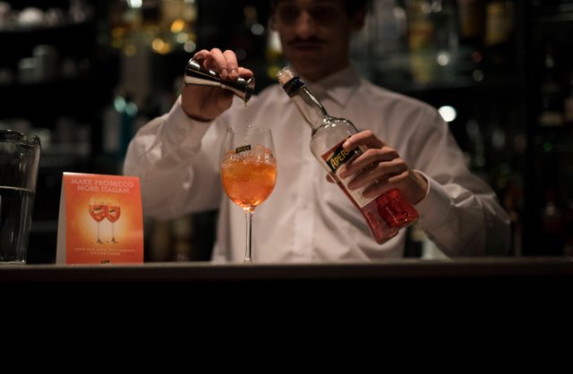 Funky barman pouring Prossecco 