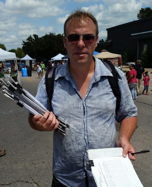 Image of Libertarian Party Petition Circulator Andrew Jacobs in Oklahoma holding Libertarian Party Ballot Access Petitions while Working On a Paid Petition Drive