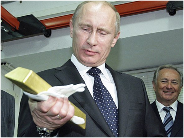 Russian Prime Minister Vladimir Putin (C) holds a gold bar while visiting the Central Depository of the Bank of Russia next to Georgy Luntovsky (L), first deputy chief of the Central Bank of Russia, on January 24, 2011 in Moscow. AFP PHOTO/ALEXSEY DRUGINYN/RIA NOVOSTI (Photo credit should read Alexsey Druginyn/AFP/Getty Images)