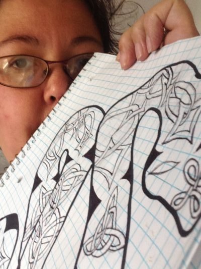 Meredith Loughran posing with doodle art Celtic snake