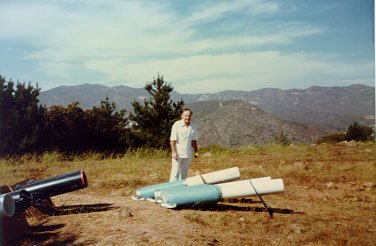 HATFIELD FLAT, CALIFORNIA, 1984 Long series of experiments to engineer rain into Los Angeles in July, when region is statistically rainless, required ten years of avocational work. Operator here stands with "bazooka" type devices, which coupled a Wilhelm Reich-type "accumulator" into a projective resonant section (white). Hatfield Flat is about 14 miles east of San Diego and 1200 feet above sea level. Excellent results were obtained.