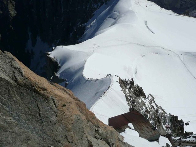 Mountaineers traversing the arête from the Col Du Midi onto a high-altitude plateau ready for the ascent of Mont Blanc.
