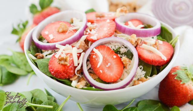 strawberries, red onions,and spinach in white bowl