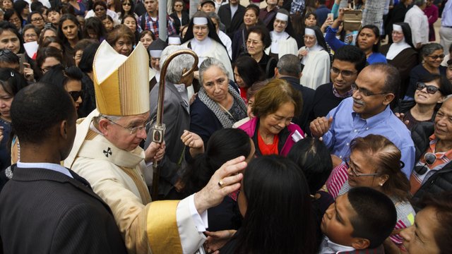 Los Angeles Archbishop José H. Gomez is surrounded by parishioners after the door closing ceremony m