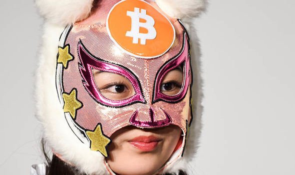 A member of Japanese pop group 'Virtual Currency Girls', wearing a mask with the symbol for BTC