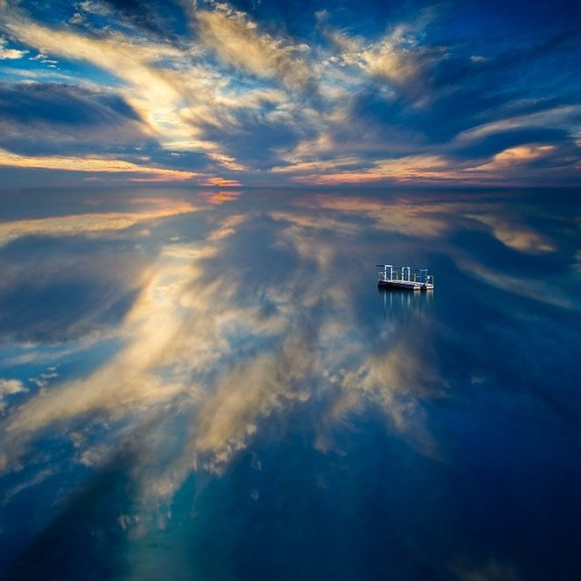 diving dock in the middle of the water with beautiful clouds reflected