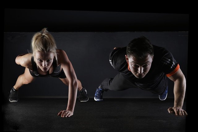 man and woman doing one-armed push-ups