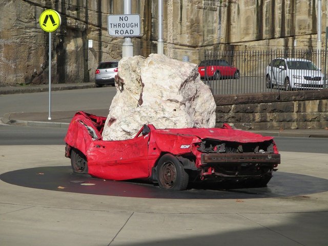 car crushed by large boulder