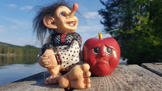 troll sitting next to sad apple