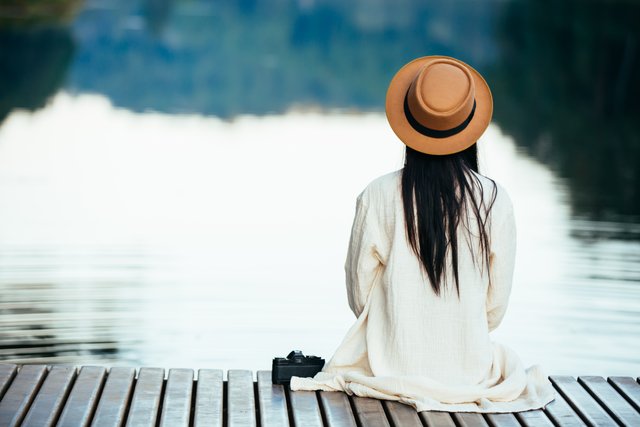 lonely-woman-sitting-on-the-waterfront-raft.jpg