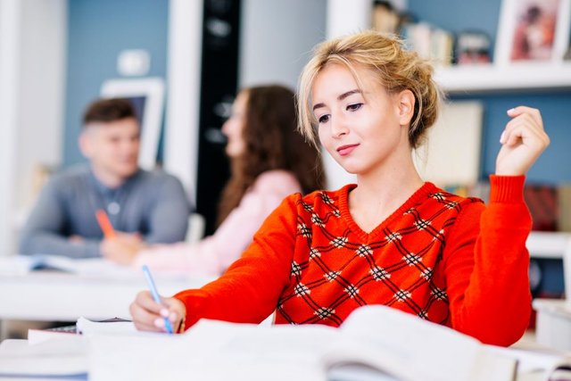 young-female-writing-textbook-library1.jpg