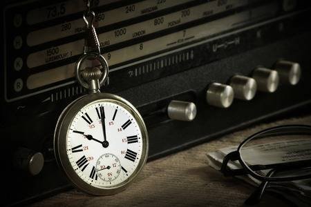 55728325-pocket-watch-with-radio-glasses-and-newspaper-on-wooden-table.jpg