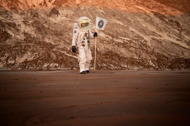 male-astronaut-holding-flag-stuck-soil-unknown-planet_23-2149240617.jpg