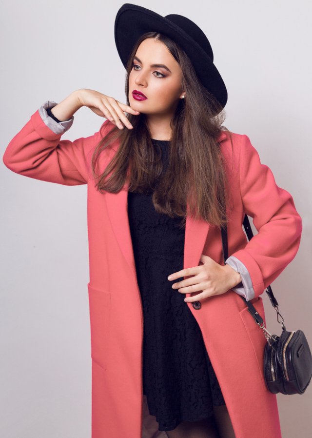 fashionable-woman-pink-coat-black-hat-posing.jpg