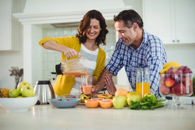 pikwizard-happy-couple-preparing-smoothie-in-kitchen.jpeg