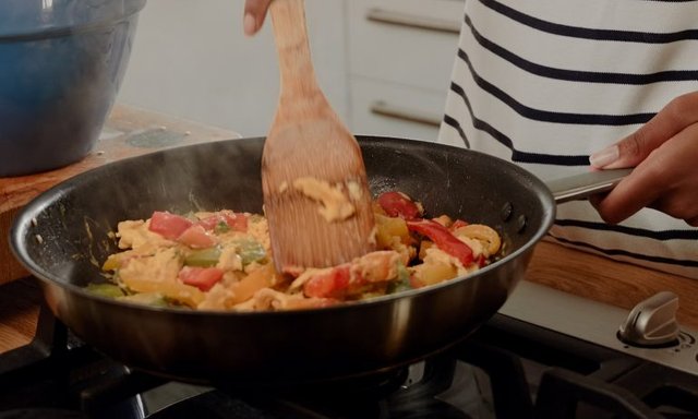 woman-mixing-ingredients-and-vegetables-in-pan-while-preparing-lunch-768.jpg