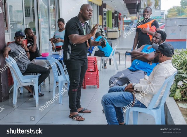 stock-photo-cheras-malaysia-august-a-number-of-nigerian-immigrants-gather-at-the-sidewalk-of-a-1475363210.jpg