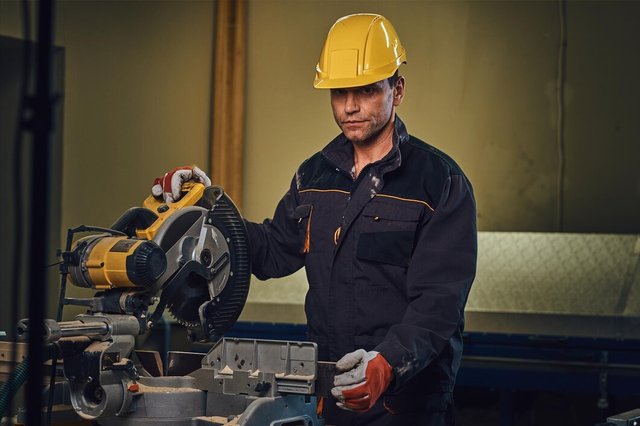 carpenter-male-dressed-safety-yellow-cap-works-with-chain-saw-garage_613910-12093.jpg