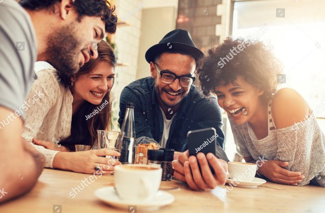 stock-photo-portrait-of-cheerful-young-friends-looking-at-smart-phone-while-sitting-in-cafe-mixed-race-people-378721525~2.jpg