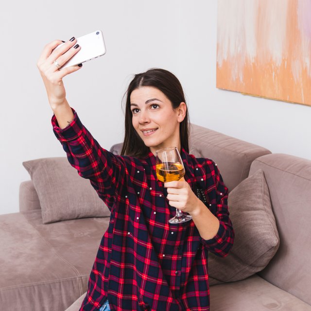 young-woman-holding-wineglass-hand-taking-selfie-mobile-phone.jpg