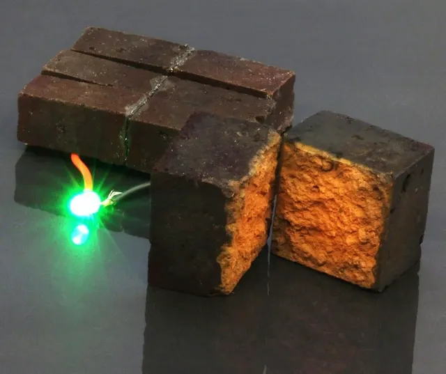 Red-brick-device-developed-by-chemists-at-Washington-University-in-St.-Louis-lights-up-a-green-light-emitting-diode-DArcy-laboratory-Washington-University-in-St.-Louis-0bad91b.webp