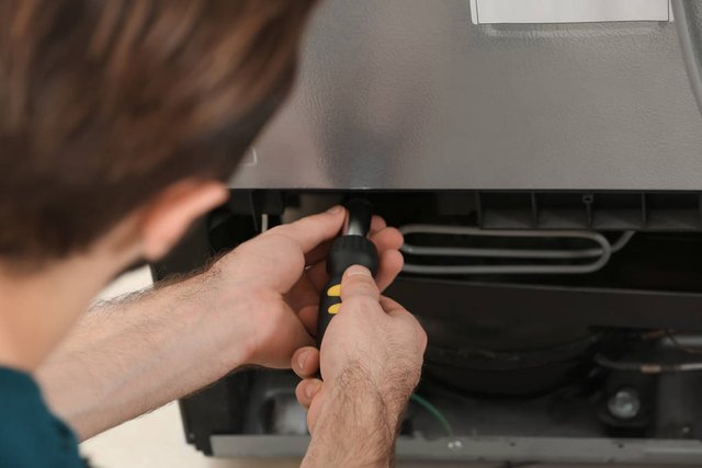 stock-photo-male-technician-repairing-refrigerator-closeup.jpg