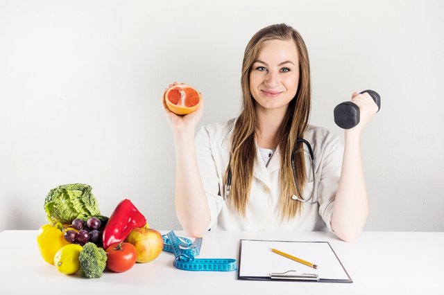 female-dietician-holding-grapefruit-dumbbell-clinic_23-2147882180.jpg