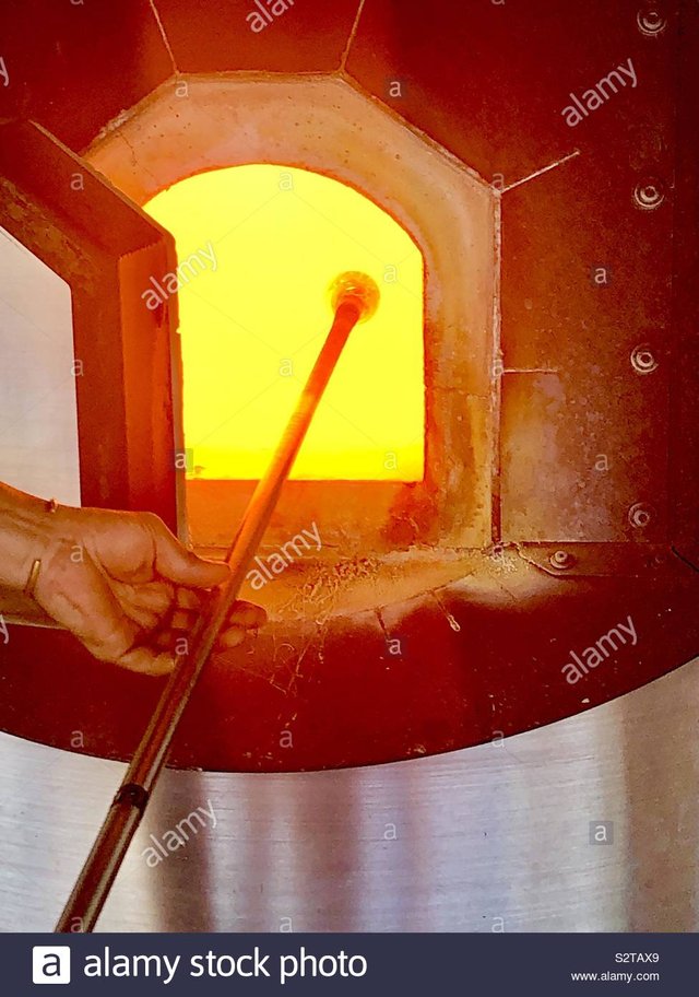 molten-glass-on-end-of-glass-blowing-rod-being-lifted-out-of-the-glory-hole-furnace-S2TAX9.jpg