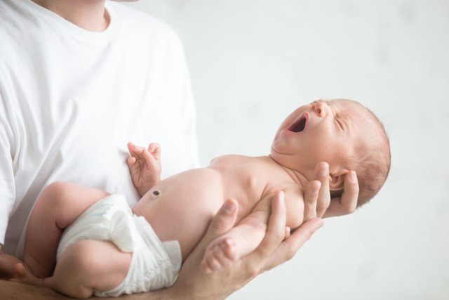 male-hands-holding-screaming-newborn.jpg