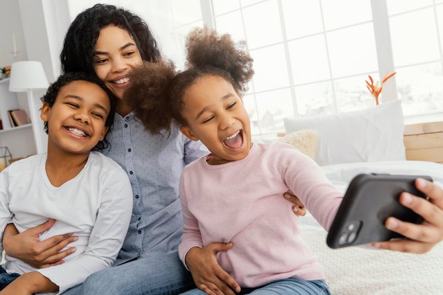 smiley-mother-children-taking-selfie-home.jpg