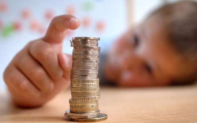 25994588_A_young_boy_pictured_with_a_stack_of_coins_sat_at_a_desk_Image_shot_2007_Exact_date_unknown-xlarge_trans_NvBQzQNjv4BqDED8W8nT5gQ4SRyNA7YCbCvIVj0v5nFdG2ZwNsXKBuw.jpg