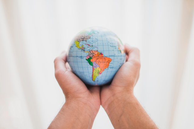 person-s-hand-holding-small-globe.jpg