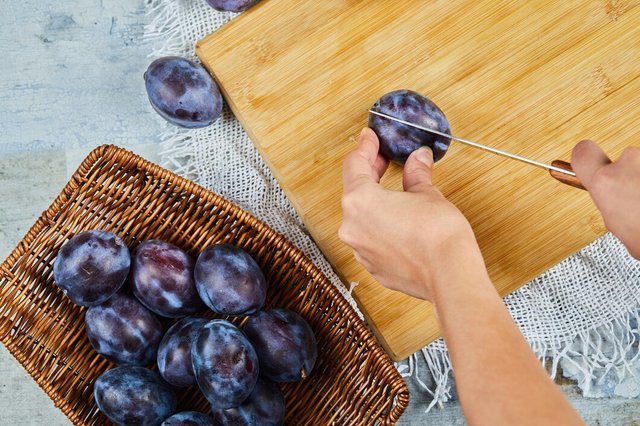 cutting-fresh-plum-wooden-board-with-basket-plums_114579-30932.jpg